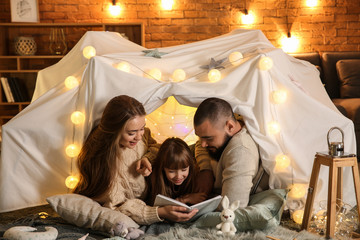 Happy family reading book at home