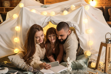 Obraz na płótnie Canvas Happy family reading book at home