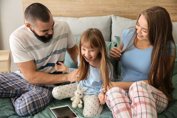 Happy family playing on bed at home