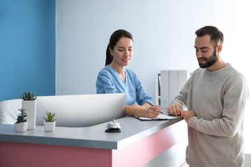 Young man near reception desk in clinic