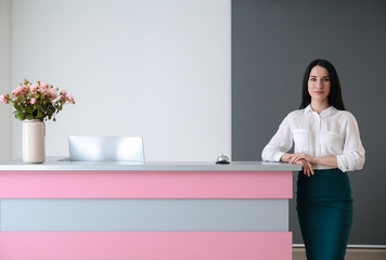 Female receptionist near desk in hotel