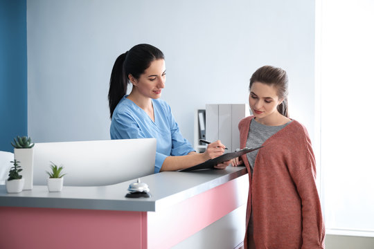 Young woman near reception desk in clinic