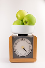 vintage wooden kitchen scales isolated on white background  with green apples