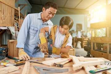 Boy drilling wooden planks