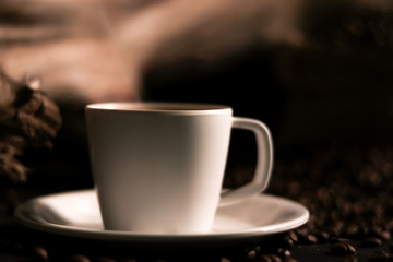 cup of coffee on the window light with coffee beans