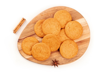 Ginger biscuits, a cinnamon stick, and an anise star, shot from the top on a white background with a place for text