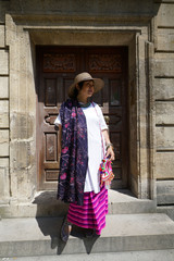 Fototapeta premium Femme posant devant une porte ancienne de l'hôtel de Sully à Paris