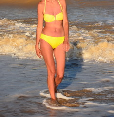 woman on vacation posing for a photographer near the wall of the face is not visible