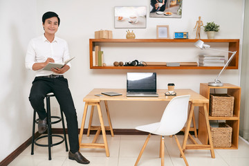 Handsome businessman writing in planner