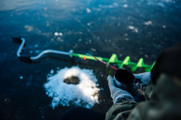 A man is fishing on the ice in the winter. Winter fishing