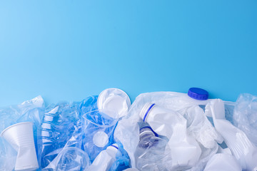 Used clean plastic garbage in a pile. Bottles and bags on blue background. Concept of waste sorting
