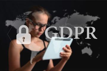 Girl in glasses working at a computer on a dark background with copy space