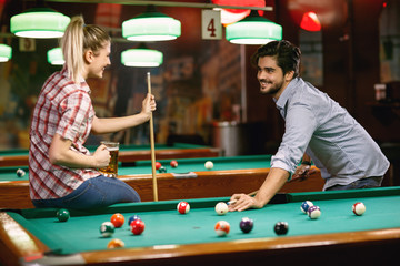 Fototapeta premium young couple enjoying playing billiard .