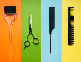 Tools hairdresser on the background of pastel paper in the form of multi-colored stripes. Minimalist pop art concept.