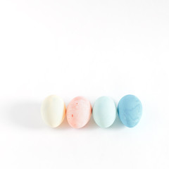 four easter colored eggs on white background