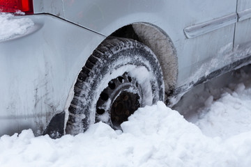 Closeup of car wheel stuck in snow