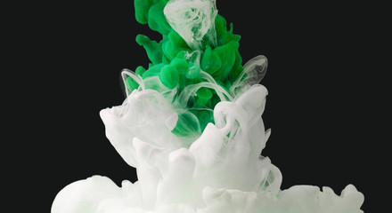 Green and white color paint drops in water