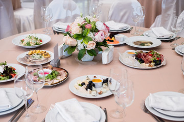Served for banquet restaurant table with dishes, snack, cutlery, wine and water glasses, european food, selective focus