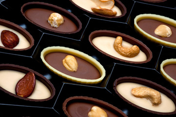 Closeup of assorted chocolates with peanut, cashew, hazelnut and almond nuts