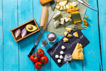 different types of cheese on a blue wooden table