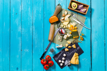 different types of cheese on a blue wooden table
