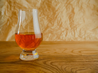 Irish Whiskey Glass on Wood and Paper Background Close Up