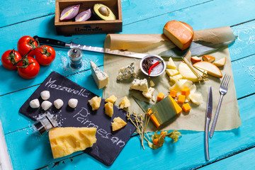 different types of cheese on a blue wooden table
