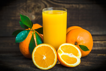 Juicy oranges and fresh juice on wooden table