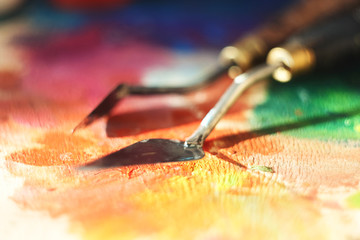 Two palette knife: one is large and straight, the other is smaller and lies on its side on a...