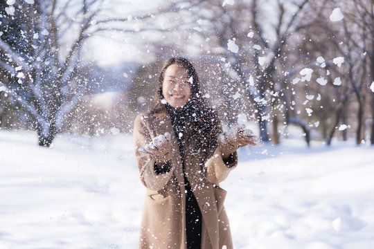 Smiling woman playing in the snow
