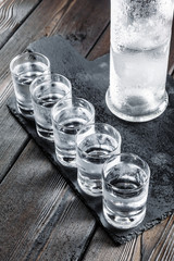 Vodka in shot glasses on rustic wood background