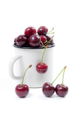 Obraz na płótnie Canvas White cup with red sweet cherry isolated on a white background..