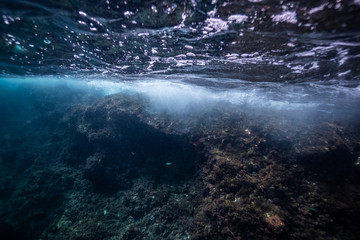 half over half underwater shot on a beautiful bay in Palma de Mallorca, Coast line water line macro shot, underwater photography with a dome port