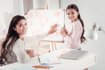 Disciplined mother and respectful daughter distributing family duties