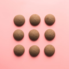 Nine cookies in row in pink background. Flat lay. Top view.