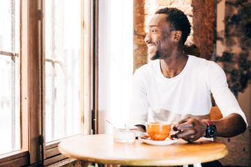 Handsome african man drinking a coffee in establishment