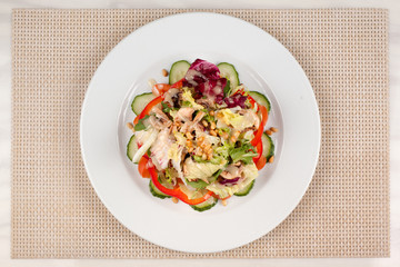 Vegetable salad with corn and mushrooms on a white plate on the table.
