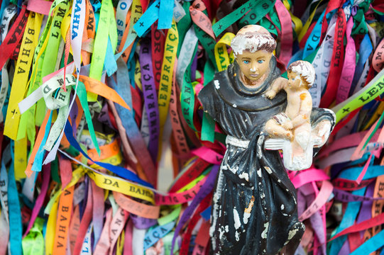 A damaged statue with the Baby Jesus stands among colorful Brazilian wish ribbons at the famous Church of Bonfim in Salvador, Bahia, Brazil (translation: Memory of the Lord of Good End)