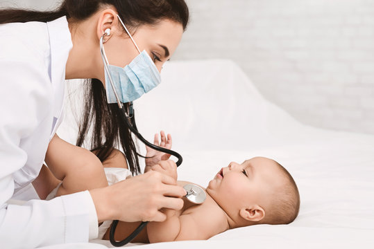 Pediatrician examining lungs of baby with stethoscope
