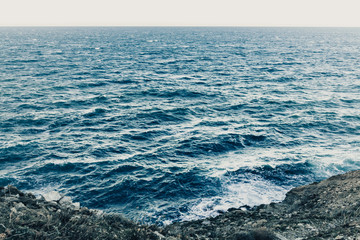 Waves in a turbulent and powerful sea, a windy day. Color blue.
