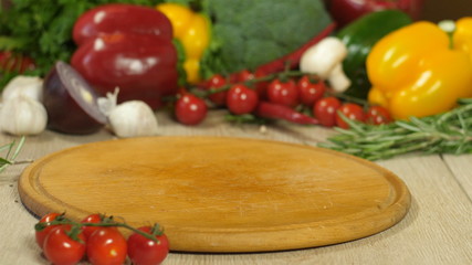 wooden round board, in the background vegetables, the background is blurred, macro, side view