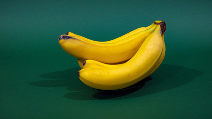 A bunch of bananas on a green background