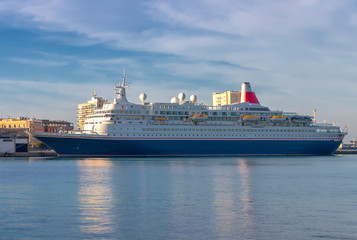 Fototapeta na wymiar Cruise ship moored in Cadiz bay port at sunset