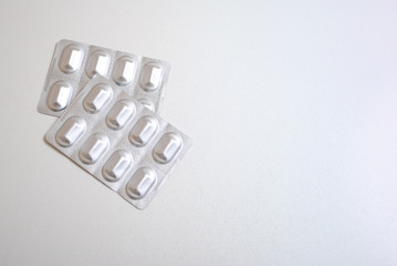 Blister capsules. Capsule pills medicine in silver aluminium blister pack isolated on white background with copy space for text. Pharmaceutical packing manufacturing concept.