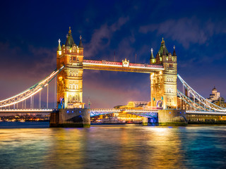 Beautiful evening scene with the famous Tower Bridge of London illuminated and reflected in river Thames