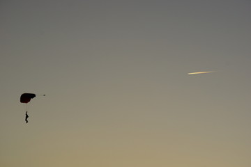 Um paraquedista junto com um avião riscando o céu de boituva no centro nacional de paraquedismo