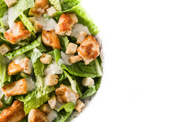 Caesar salad with lettuce,chicken and croutons isolated on white background. Top view. Copyspace