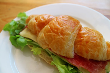 Delectable ham and cheese with fresh lettuce croissant sandwich