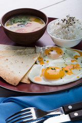 Asian breakfast of rice, soup and fried eggs