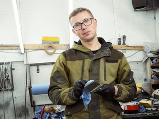 Cute guy in black glasses with black gloves displays the shape of the hood for the subsequent...